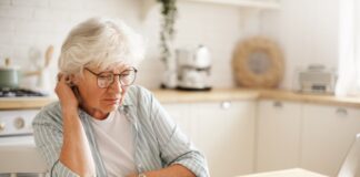 Starsza kobieta wyliczająca ile może zarabiać, aby jej emerytura nie uległa zmniejszeniu