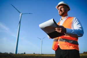 Inżynier stoi przy turbinie wiatrowej