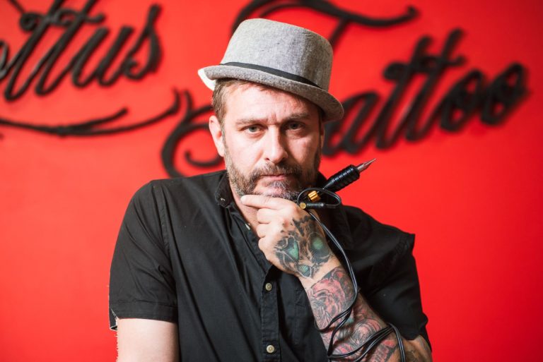 Tatuażysta w swoim salonie tatuażu