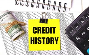 Napis "historia kredytowa", pieniądze, kalkulator i wykaz płatności