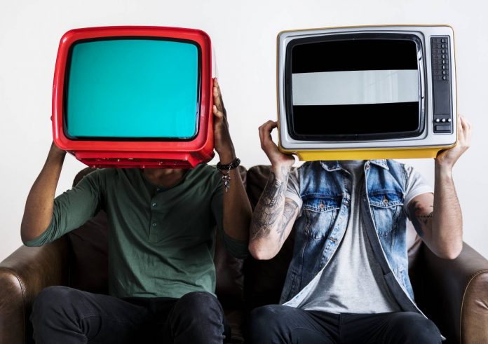 Mężczyźni trzymają stare telewizory