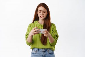 Dziewczyna grająca w grę mobilną irytuje się mikropłatnościami