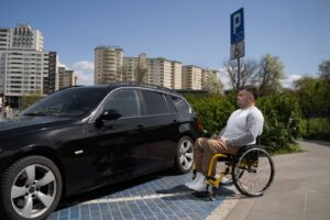 Osoba niepełnosprawna wchodzi do samochodu